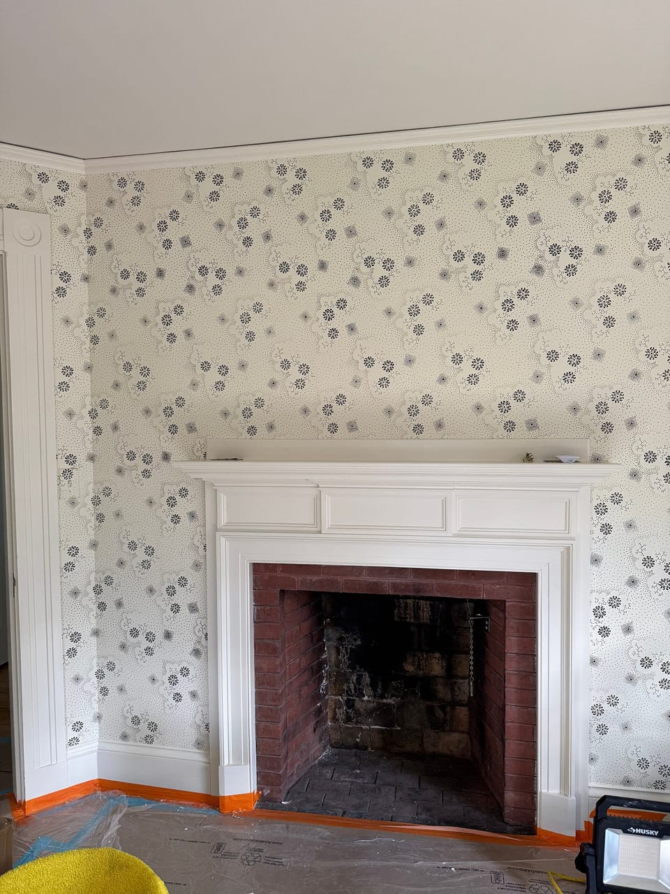 Floral print around a white fireplace mantel