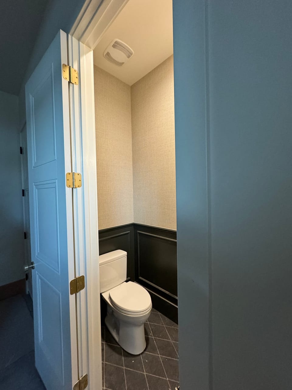 Grasscloth in a powder room with dark wainscot