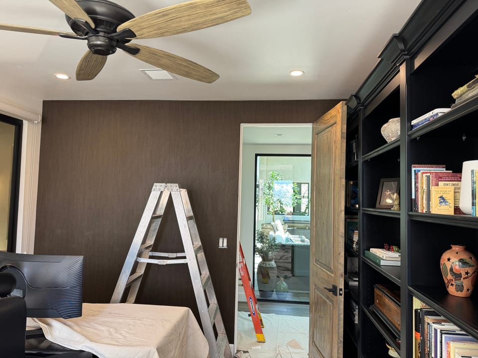 Office wall beside dark bookshelves