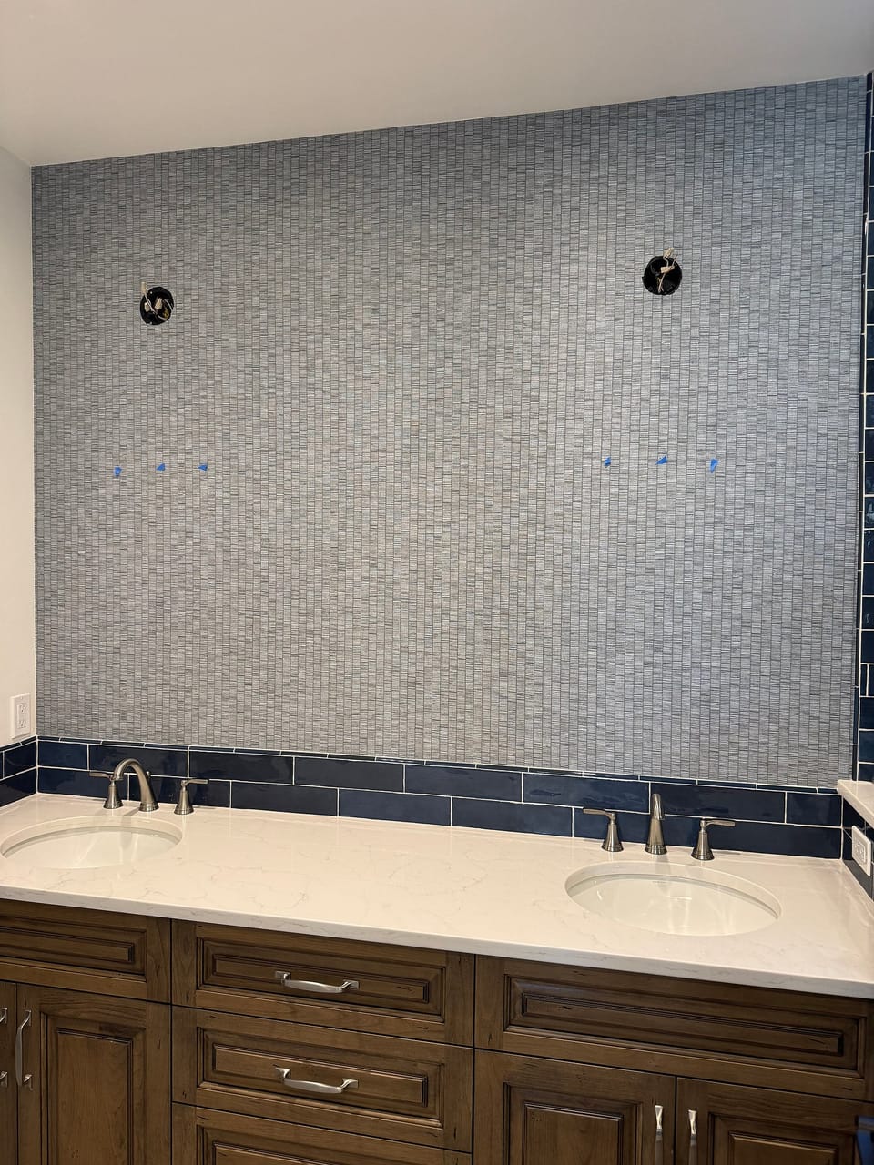 Textured wallcovering above a bathtub with navy tile